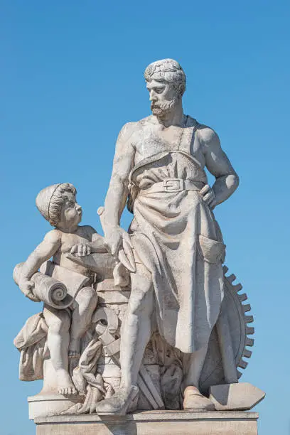 Photo of Elderly and young – old sculpture of engineer and his scholar on Zoll Bridge in Magdeburg downtown at blue sky background, Germany, details, closeup