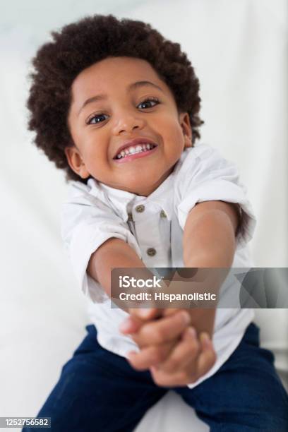 Cute Little Black Boy Pleading While Facing Camera Smiling Stock Photo - Download Image Now