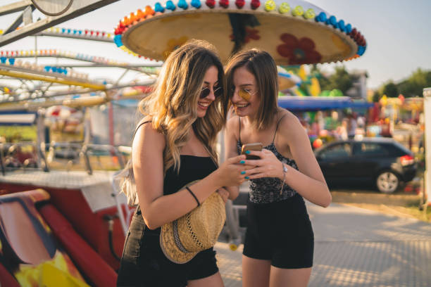 istock Happy girlfriends are make fun together in fun fair 1252757809