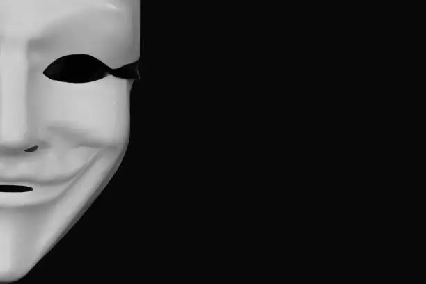 Photo of White mask isolated on a black background.