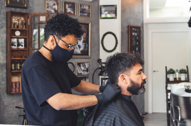 istock Barber putting neck cover paper in a client with cape 1252762509