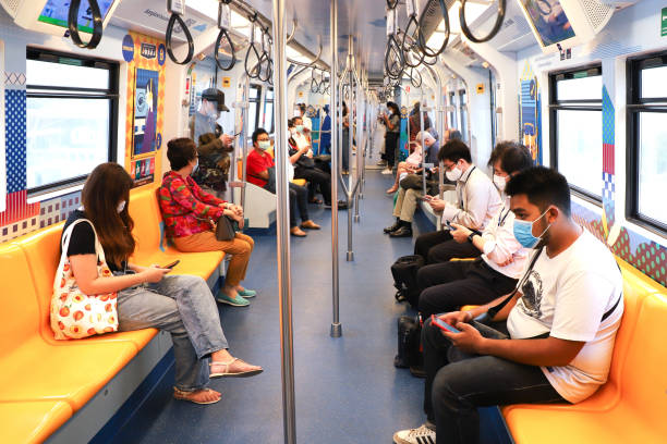 Bangkok metro people in a medical mask inside the car BTS Skytrain. Bangkok metro people in a medical mask inside the car BTS Skytrain. Thailand Bangkok March 2020 bts skytrain stock pictures, royalty-free photos & images