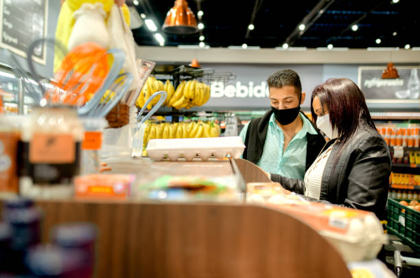 istock Couple shopping at grocery store, using mask 1252764285