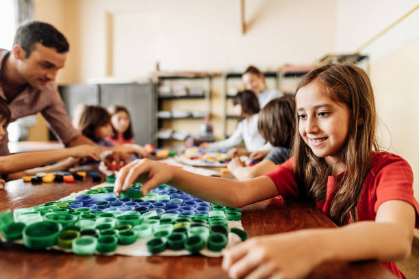 Kids making art in classroom with recycled plastic