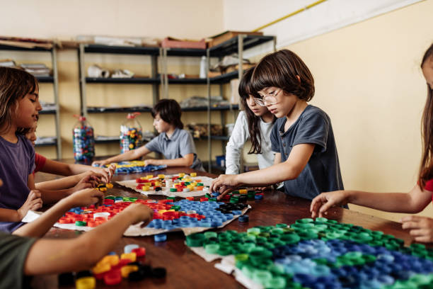 istock Latino teacher with Hispanic kids in classroom at school, doing creative work together 1252770776