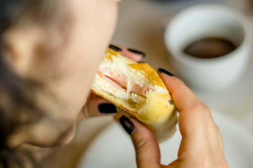 Close up of woman's hand holding sandwich