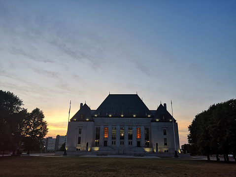 Ottawa, Canada - June 20, 2020: The Supreme Court of Canada is situated in downtown Ottawa.  It is Canada's highest court and issues decisions on a wide range of issues from the status of Uber drivers to the right of Canadians to have medical assistance in dying.  Construction began in 1939 in an Art Deco style.  Statues of Truth and Justice flank the central stairwell.