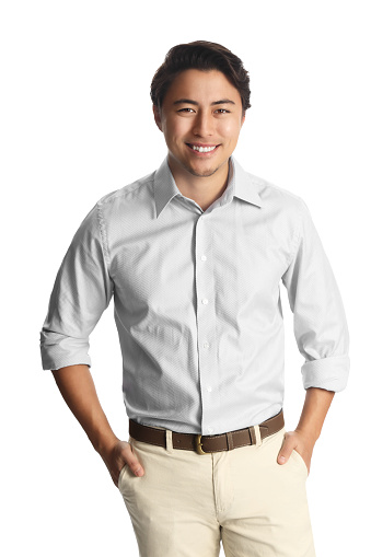 A successful asian male entrepreneur smiling confidently with both hands in his pocket
wearing a white collared shirt isolated against a white background.
