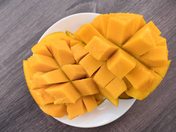 istock Half cutted cubes slices ripe mango on white plate 1252795674
