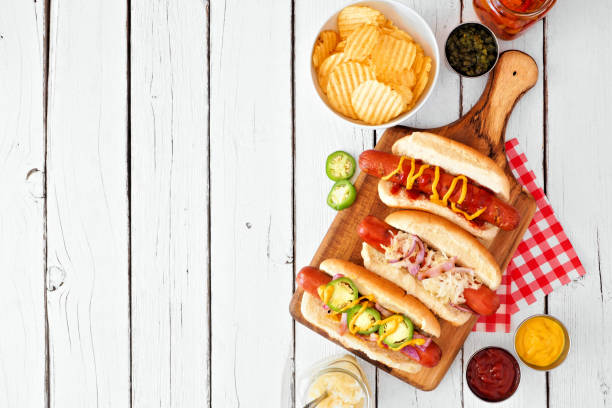 vielzahl von bbq hot dogs, über blick über einen weißen holzhintergrund mit kopierraum - relish stock-fotos und bilder