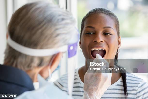 Woman Opens Mouth For Cheek And Throat Swab While Being Tested For Covid19 Coronavirus Stock Photo - Download Image Now