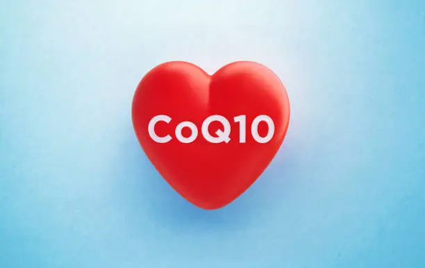 CoQ10 written red heart shape on blue background, Horizontal composition with copy space. Heart care and CoQ10 concept.