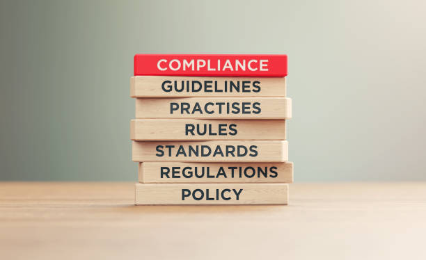 compliance related words written wood blocks sitting on wood surface in front a defocused background - ruled lines stock-fotos und bilder