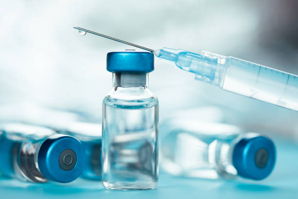 istock Vaccine injectable vials and syringe close up in blue tones 1252804949