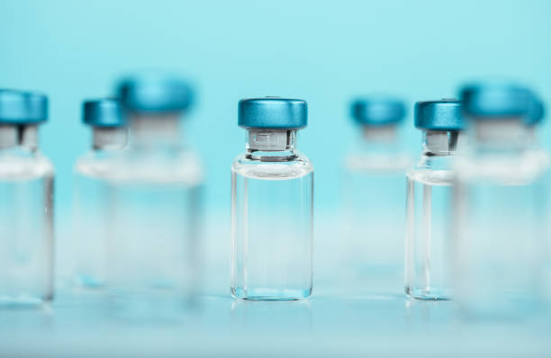 istock Vaccine injectable vials and syringe close up in blue tones 1252804964