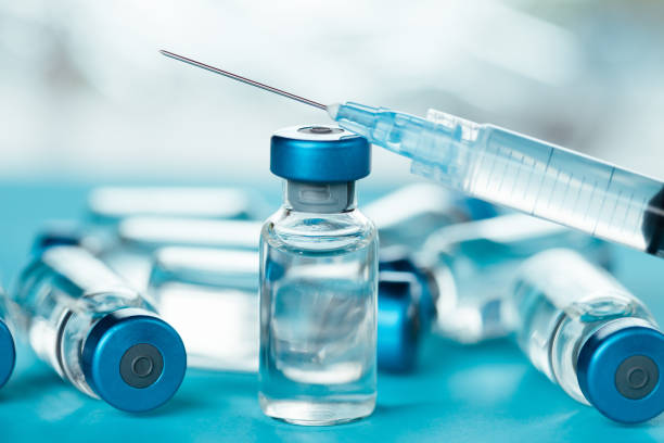 istock Vaccine injectable vials and syringe close up in blue tones 1252804990