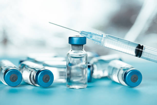 istock Vaccine injectable vials and syringe close up in blue tones 1252804991
