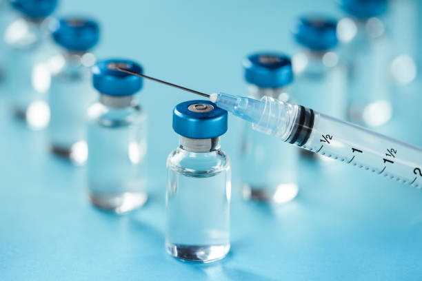 istock Vaccine injectable vials and syringe close up in blue tones 1252804992