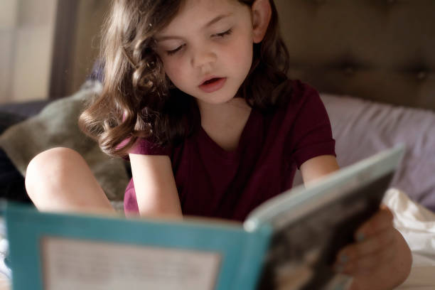 istock Girl reading book on bed 1252809469