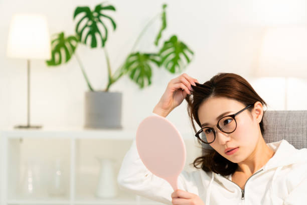 mujer asiática para ver un espejo, cuidado del cabello, - white hair fotografías e imágenes de stock