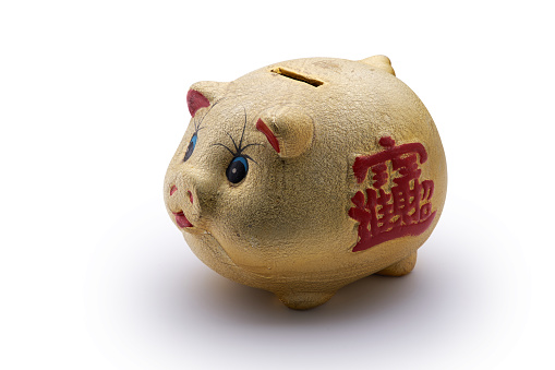 Typical Chinese Business Piggy Bank Held By Hands, with traditional Chinese characters on the Piggy Bank's side saying \