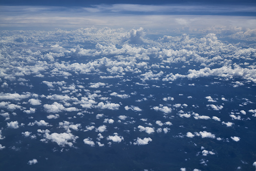Aerial View above clouds in the Sky from an Airplane