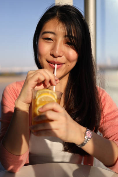 istock Young woman drinking a  lemonade at cafe 1252833908