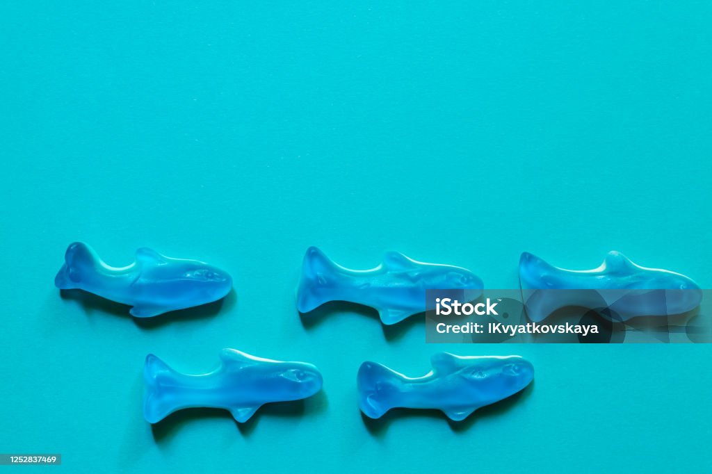 blue jelly sweets top view. Delicious marmalade. Candy in the shape of fish on blue background with copy space. blue jelly sweets top view. Delicious marmalade. Candy in the shape of fish on blue background with copy space Candy Stock Photo