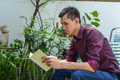 Asian man reading a book at outdoor garden