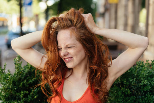 jeune femme frustrée tirant à ses longs cheveux - beautiful red hair curly hair human hair photos et images de collection