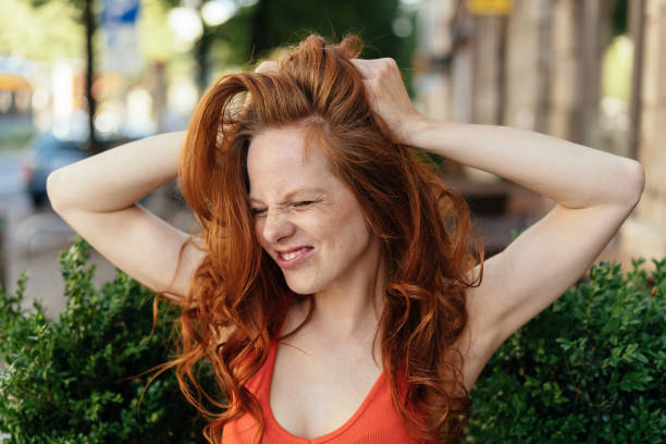 istock Frustrated young woman pulling at her long hair 1252838380