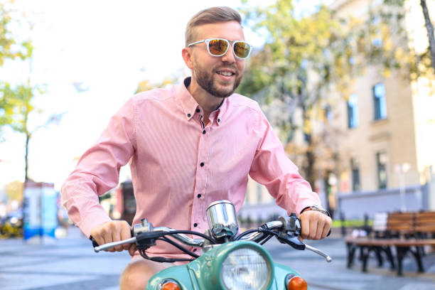 istock Happy handsome man riding on scooter in the city. 1252842807