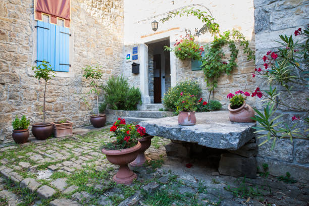 Groznjan, Croatia - July, 10: Typical Istrian courtyard with stone table and flowers on July 10, 2017