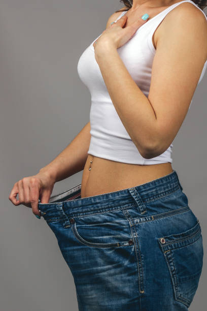 istock Woman trying on large size jeans 1252843136