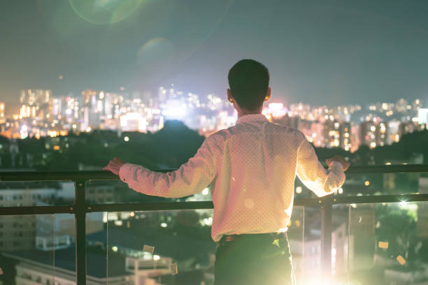 istock Businessman looking dreamlike city night 1252849378
