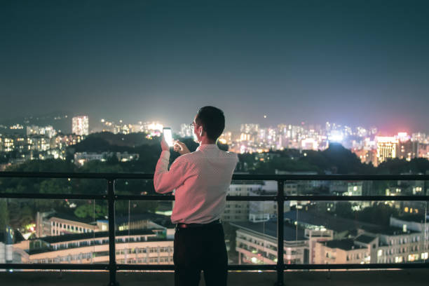 istock Businessman using phone standing on city rooftop 1252849440
