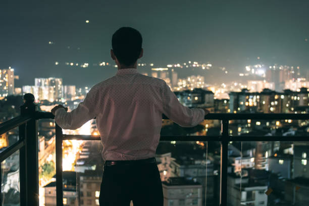 istock Businessman standing rooftop looking city night 1252849460