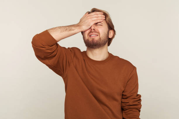 Omg, facepalm! Portrait of desperate man keeping hand on head blaming himself for bad memory, unforgivable mistake Omg, facepalm! Portrait of desperate man keeping hand on head blaming himself for bad memory, unforgivable mistake, expressing sorrow and shame emotion. indoor studio shot isolated on gray background head in hands stock pictures, royalty-free photos & images