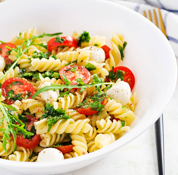 istock Pasta salad. Fusilli Pasta - Caprese salad with tomato, mozzarella and basil. 1252853607