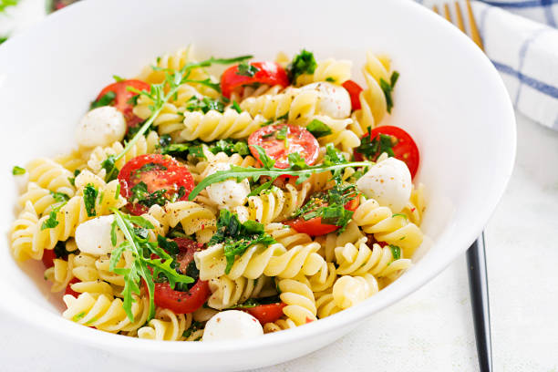 istock Pasta salad. Fusilli Pasta - Caprese salad with tomato, mozzarella and basil. 1252853613