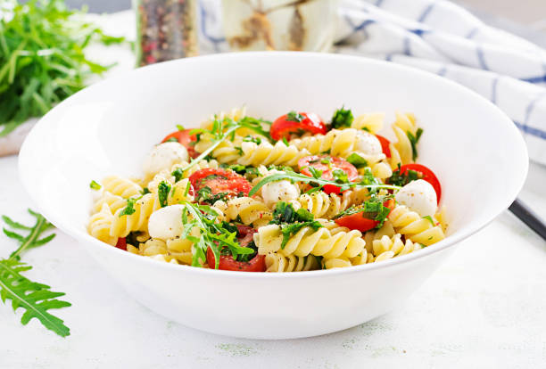 istock Pasta salad. Fusilli Pasta - Caprese salad with tomato, mozzarella and basil. 1252853614
