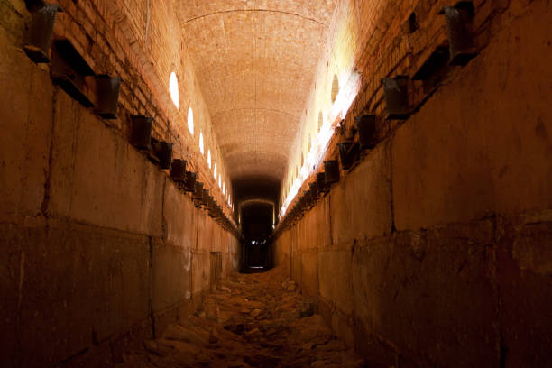istock Old ruined brick vaulted tunnel. Dark passage. Underground communication 1252853698