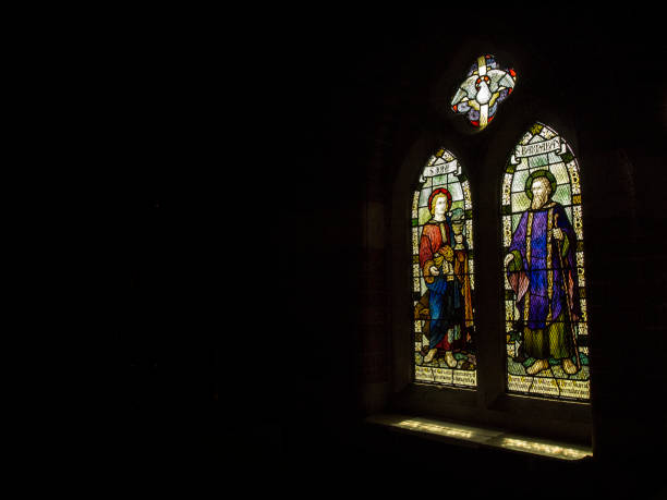 istock Stained glass windows shedding sunlight into a darkened church. 1252853771