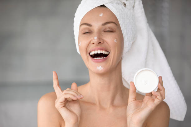 istock Happy young female using good moisturizing facial cream 1252855103