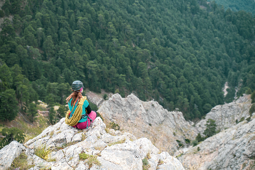 Climber is standing with climbing equipment and celebrating success at the summit of the mountain ,recorded during a climbing expedition.