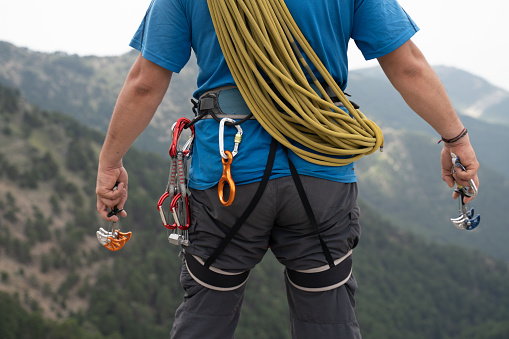 Close up shot of a rock climbing assisted belaying device and a green rope.