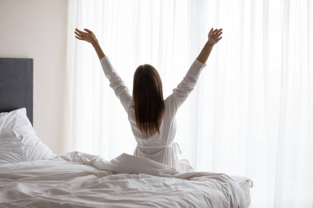 istock Back view of young female stretch in bed 1252856137