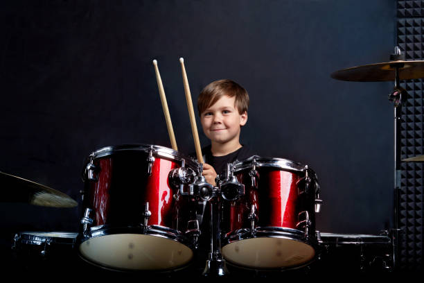 istock Cheerful smiling child plays the drums. Boys Studios. 1252856301