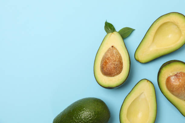 istock Ripe fresh avocado on blue background, top view 1252857244