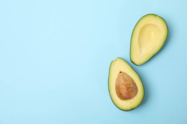 istock Ripe fresh avocado on blue background, top view 1252858061